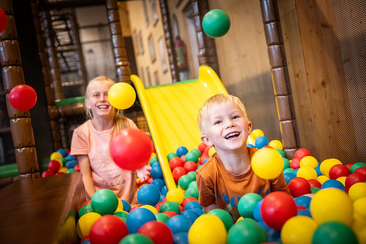 Zwei Kinder spielen im Bällebad einer Indoor-Spielscheune